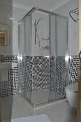 a glass shower in a bathroom with a sink at Turk Hotel in Oludeniz