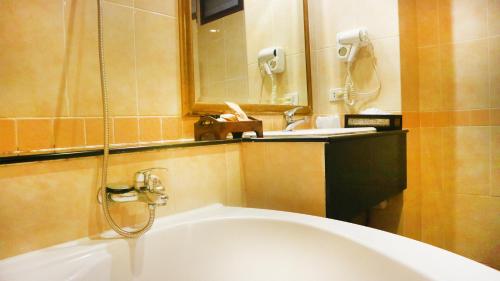a bathroom with a sink and a bath tub at Aiyaree Place Hotel SHA PLUS in Jomtien Beach