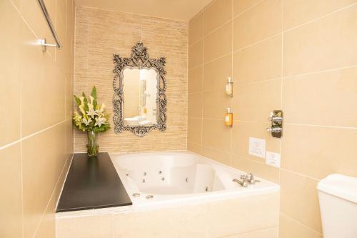 a bathroom with a bath tub with a vase of flowers at 30 James Street in Liverpool