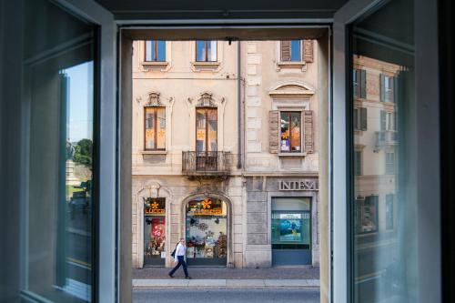 a window view of a building with a person walking in the street at Downtown Como-Porta Torre Flat in Como