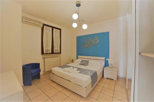 a bedroom with a bed and a blue wall at ALLORO APPARTAMENTO 1 - Piano Terra con terrazza. in Sirmione
