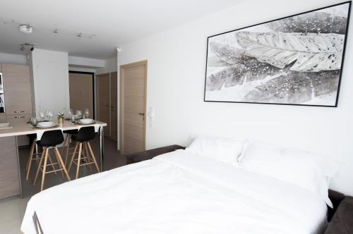 a bedroom with a white bed and a table and chairs at La Villa et sa plume in Divonne-les-Bains