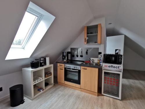 una cocina en el ático con fogones y fregadero en Apartment 1 Zimmer, en Walsrode