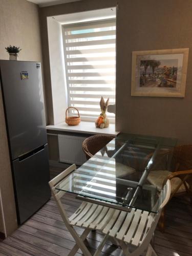 a glass table in a kitchen with a refrigerator at DAUGAVPILS in Daugavpils