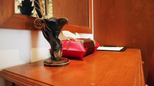 a wooden table with a box and a statue on it at Aiyaree Place Hotel SHA PLUS in Jomtien Beach