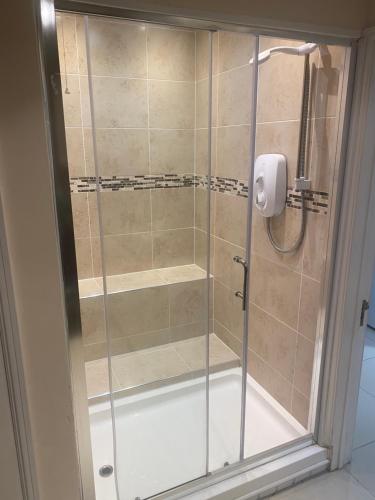 a shower with a glass door in a bathroom at Stunning guest suite with private hot tub in Rogerstone