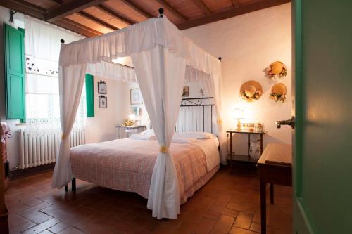 una camera con letto a baldacchino di Agriturismo San Giorgio a Monteroni dʼArbia