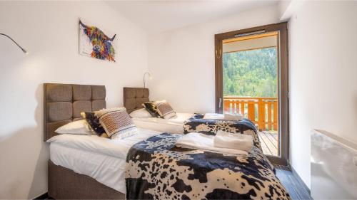 a bedroom with two beds and a window at Les Freinets - Apt A01 - BO Immobilier in Châtel