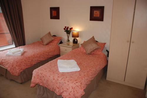 a bedroom with two beds with towels on them at Wendover Guest House in Bolton