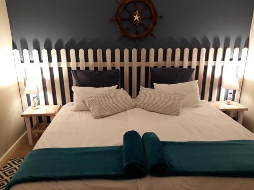 uma grande cama branca com duas almofadas e um relógio na parede em Diana's Apartment em Swakopmund