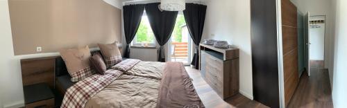 a bedroom with a bed and a dresser and a window at Harzstübl25 in Sankt Andreasberg