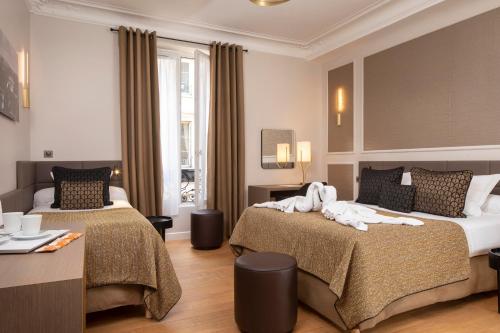 a hotel room with two beds with towels on them at Hôtel du Levant in Paris