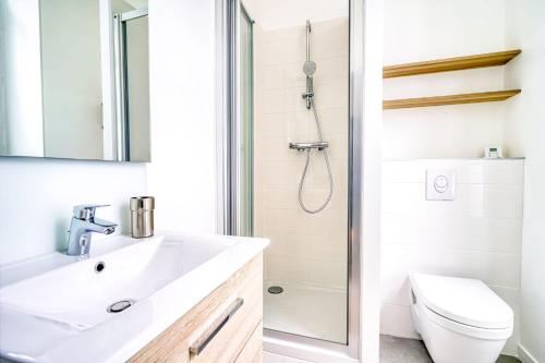 een badkamer met een wastafel en een douche bij La Reine Blanche in Dammarie-lès-Lys