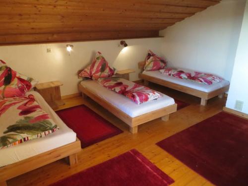 two beds in a room with red pillows on them at Ferienwohnung Bronner in Kißlegg