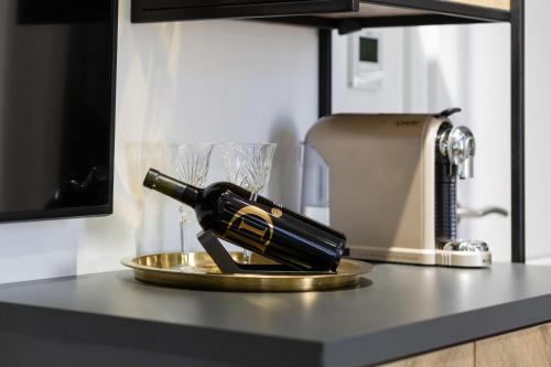 a bottle of wine on a plate on a counter at DeZign Superior Apartments & Rooms in Zadar