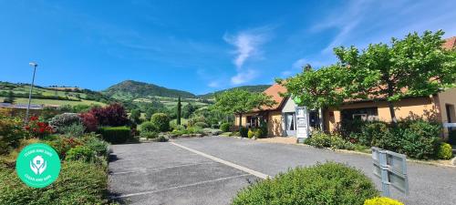 a road in front of a house with mountains in the background at Campanile Millau in Millau