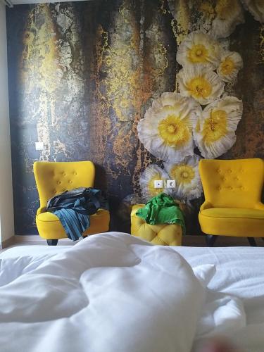 a bedroom with two yellow chairs and a bed at Sandanski Apartments Top Center in Sandanski