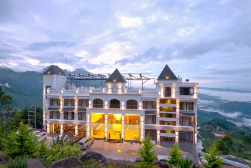 蒙納的住宿－Amber Dale Luxury Hotel & Spa, Munnar，山顶上一座白色的大建筑