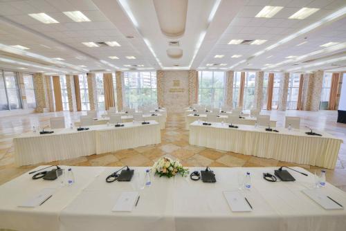 a large room with white tables and chairs at Mediteran Hotel & Resort in Budva