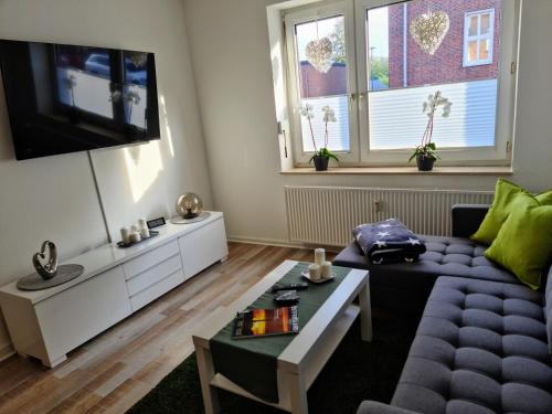 a living room with a couch and a tv at Fewo-Alter in Wilhelmshaven