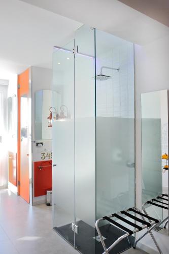 a glass shower in a bathroom with a chair at Hotel Boutique Sabbia Valencia in Valencia