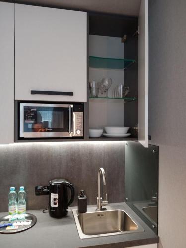 a kitchen counter with a sink and a microwave at Studio Galaxy 2 floor in Kyiv