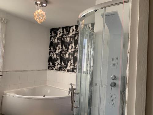 ein Badezimmer mit einer Badewanne und einer Dusche mit einer Glastür in der Unterkunft Brookfield’s Apartment in Clacton-on-Sea