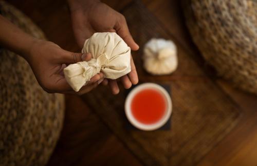 a person holding a wonton wrapper next to a cup of tea at Grand Hotel Adriatic in Opatija