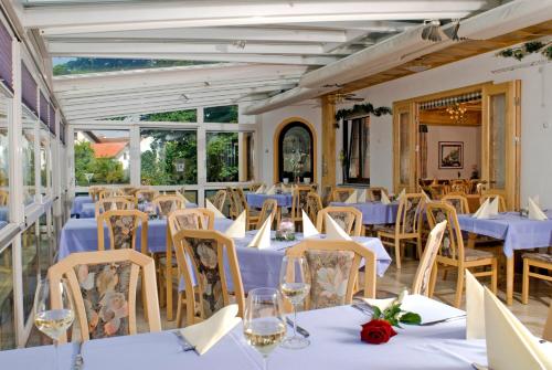un comedor con mesas y sillas blancas en Hotel Zum Fischerwirt, en Baindlkirch