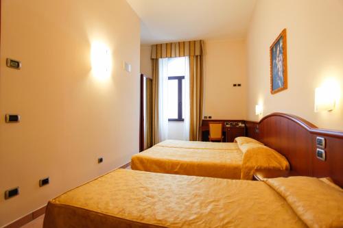 a hotel room with two beds and a window at Garda Family House in Brenzone sul Garda
