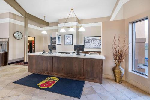 a large bathroom with a counter with a clock on the wall at Super 8 by Wyndham Casper West by the River in Casper