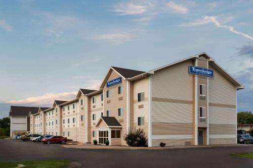 a large building with cars parked in a parking lot at Travelodge by Wyndham North Platte in North Platte