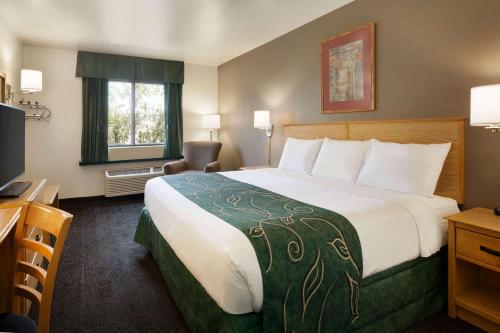 a hotel room with a large bed and a television at Travelodge by Wyndham Yermo in Yermo