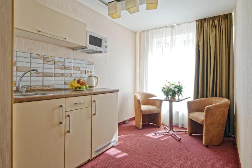 una cucina con un lavello e un tavolo con sedie di Atrium a Odessa