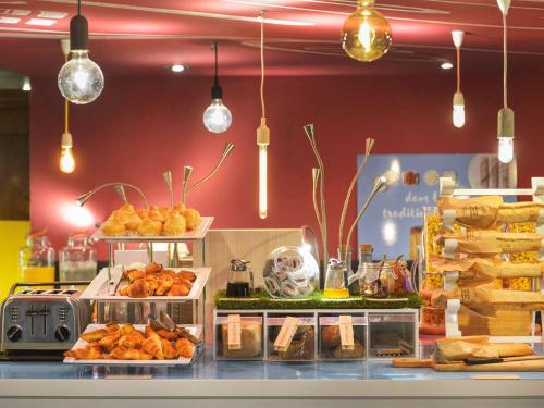 a counter filled with lots of different types of pastries at Novotel Metz Centre in Metz