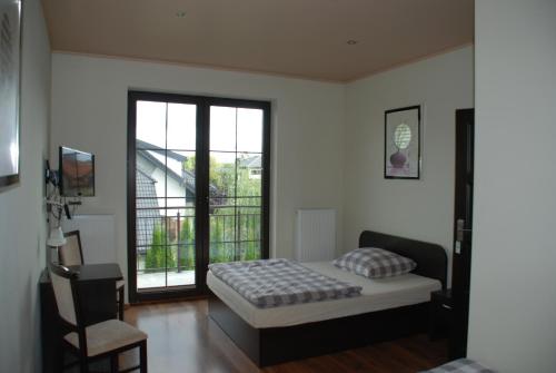 a bedroom with a bed and a window at VillaRenoma in Nadarzyn