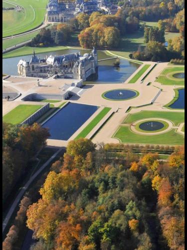 an aerial view of a large building with trees at Cocoon Retreat in Chantilly