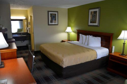 a hotel room with a bed and a desk at Quality Inn Midtown Savannah in Savannah