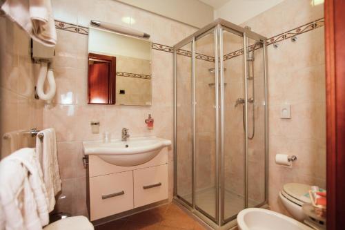 y baño con ducha, lavabo y aseo. en Garda Family House, en Brenzone sul Garda