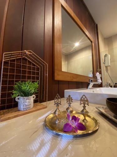 a bathroom counter with a sink and a mirror at SAK-KA-YA (สัก-กา-ยะ) in Mae Sot