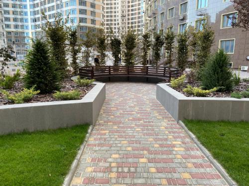 a brick walkway with a bench in a city at Панорамный вид на море 44 Жемчужина Аркадия in Odesa