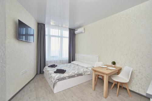 Dormitorio pequeño con cama y mesa en Панорамный вид на море 44 Жемчужина Аркадия en Odesa