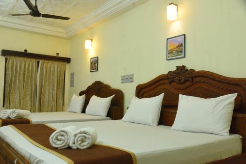 two beds in a hotel room with towels on them at Hotel Raja Palace in Kanyakumari