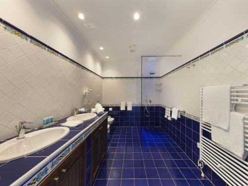 a bathroom with two sinks and a blue tiled floor at Hotel La Tonnarella in Sorrento