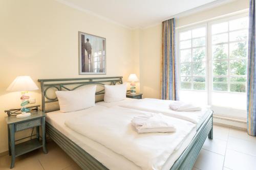 ビンツにあるSeeluft in der Villa Isabell mit Sonnenterrasseのベッドルーム1室(白いシーツ付きのベッド1台、窓付)