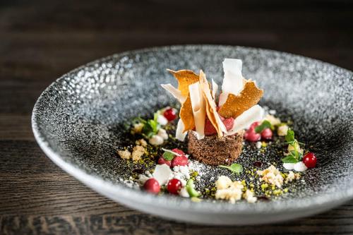 a plate with a dessert on a table at Adler Inn Tyrol Mountain Resort SUPERIOR in Tux