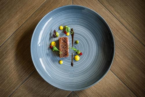a blue plate with food on top of a table at Adler Inn Tyrol Mountain Resort SUPERIOR in Tux