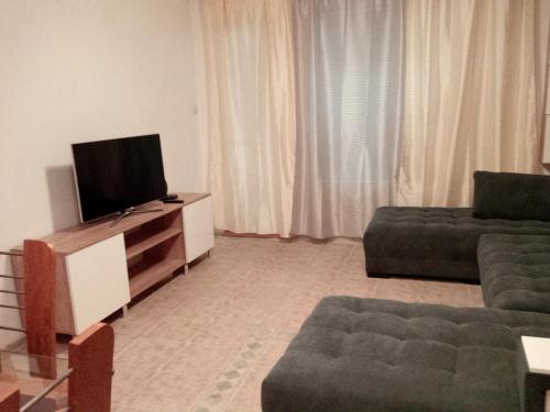 a living room with a television and a couch at Просторен и добре обзаведен апартамент Oborishte 39 str in Plovdiv
