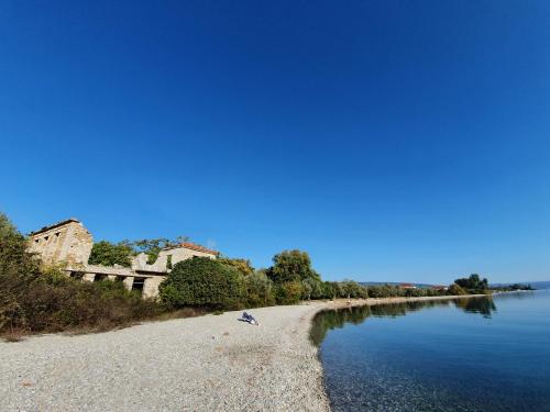 a sandy beach next to a body of water at Kala Nera Panorama in Kala Nera