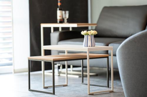 a coffee table with a vase of flowers on it at Refugium am Wasserturm in Emsdetten